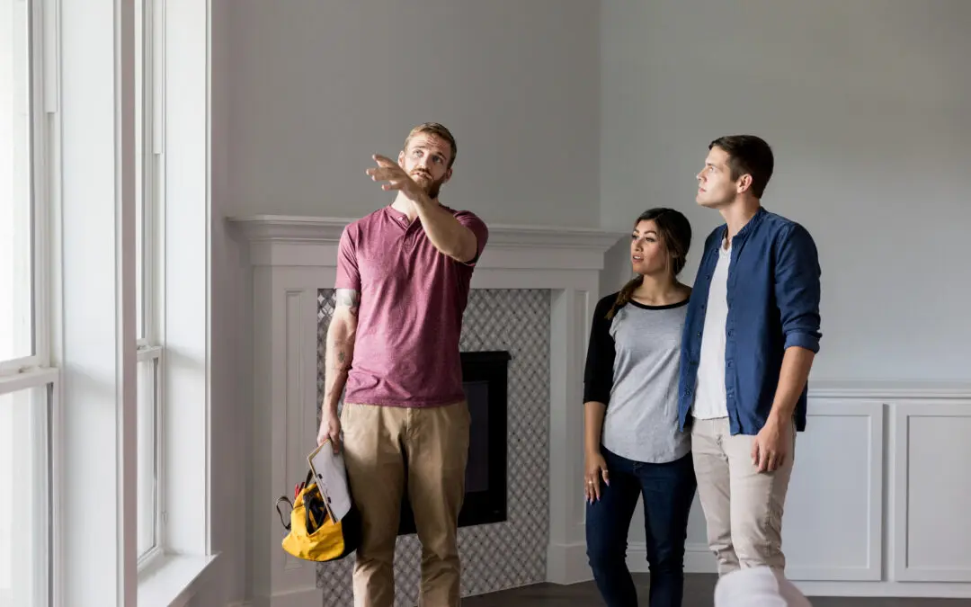 Handyman discussing a list of home repairs with homeowners.