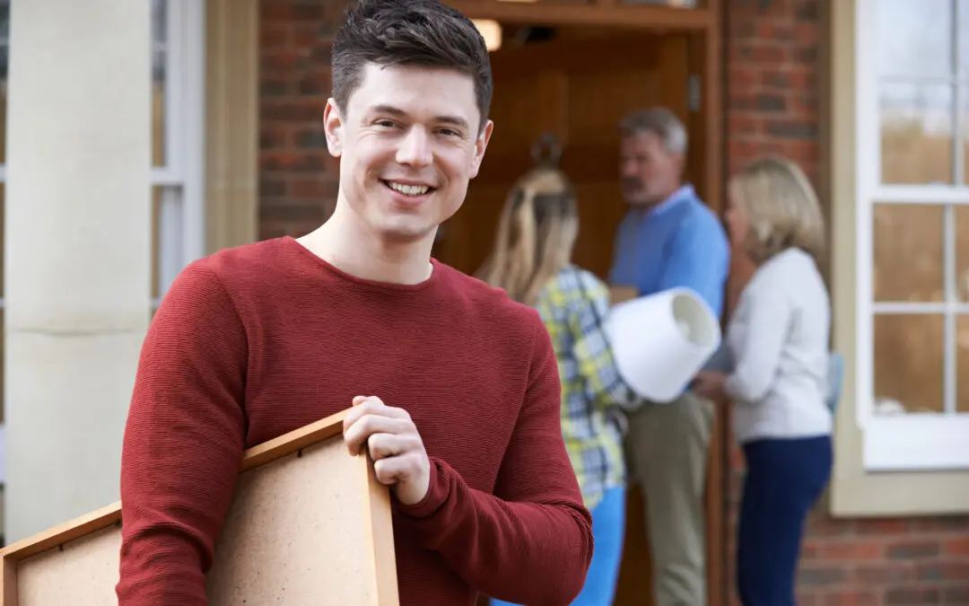 People carrying belongings into a home during move-in.